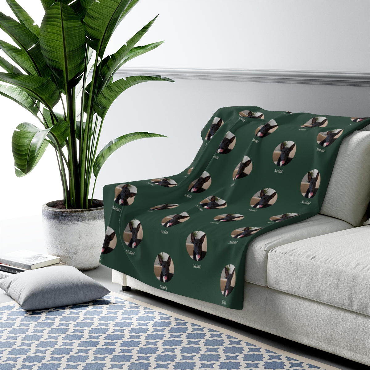 Lifestyle mockup: The Studio Blanket draped over a sofa, with our sample portrait