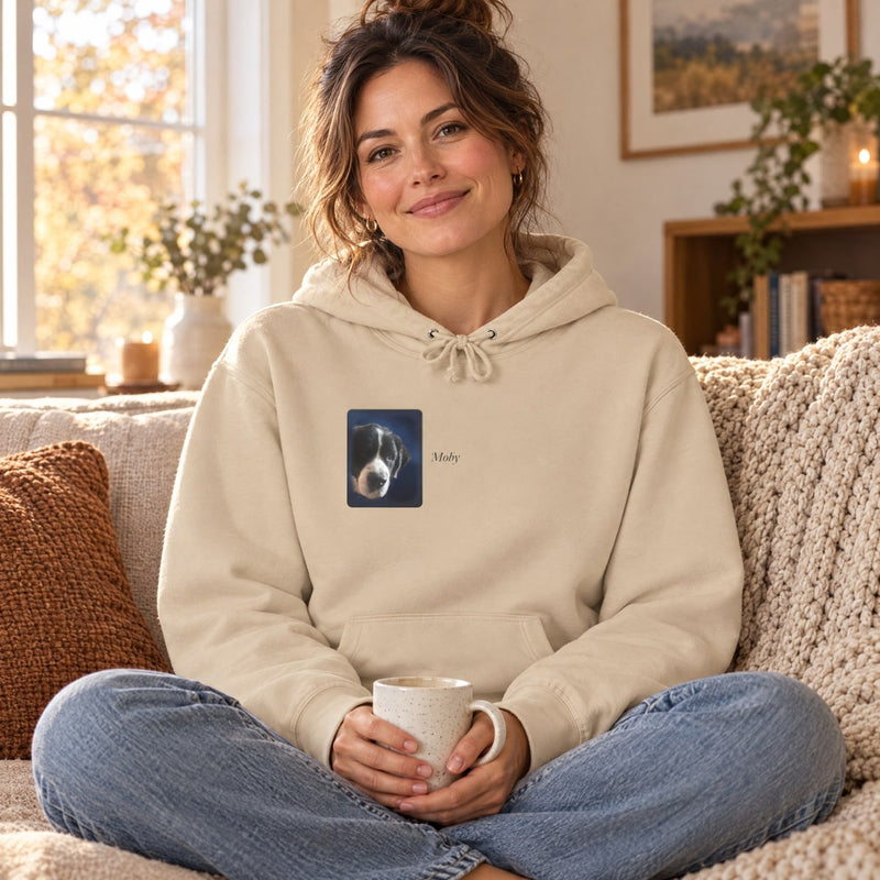 Lifestyle mockup: The Studio Hoodie worn on a sofa, with our sample portrait