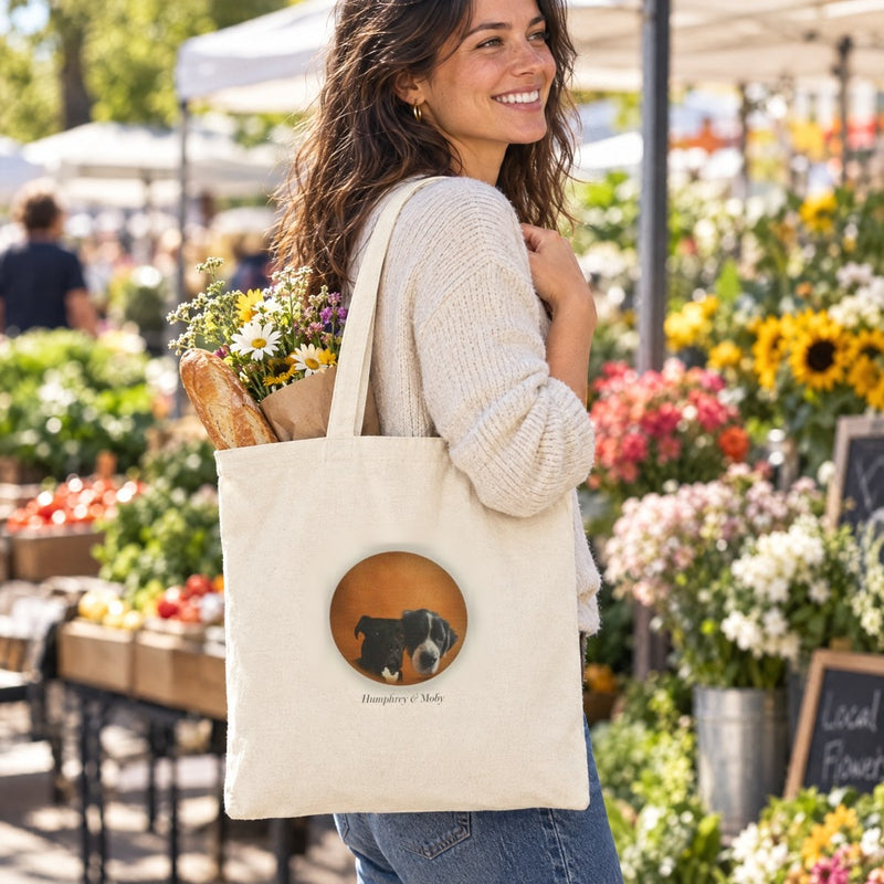 Lifestyle mockup: The Errands Tote worn at a farmers market, with our sample portrait