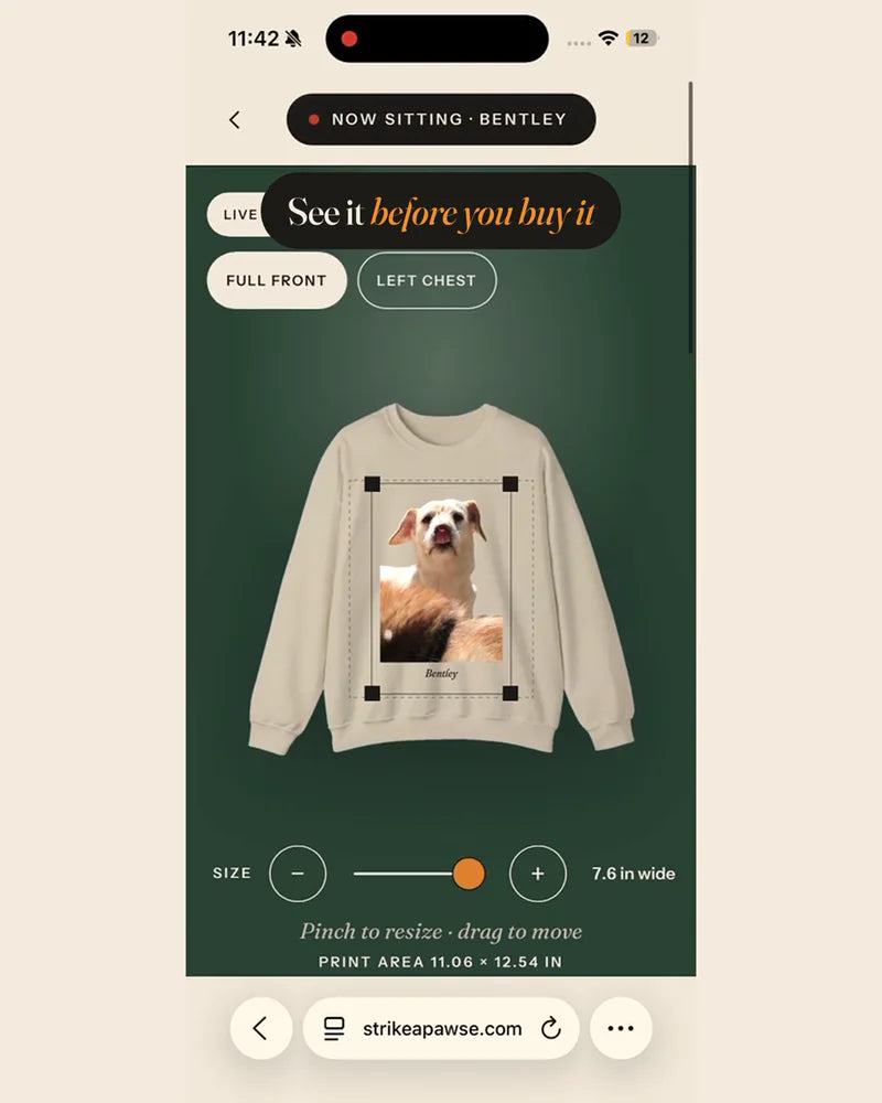 The studio on a phone, previewing a dog's portrait on a cream crewneck.